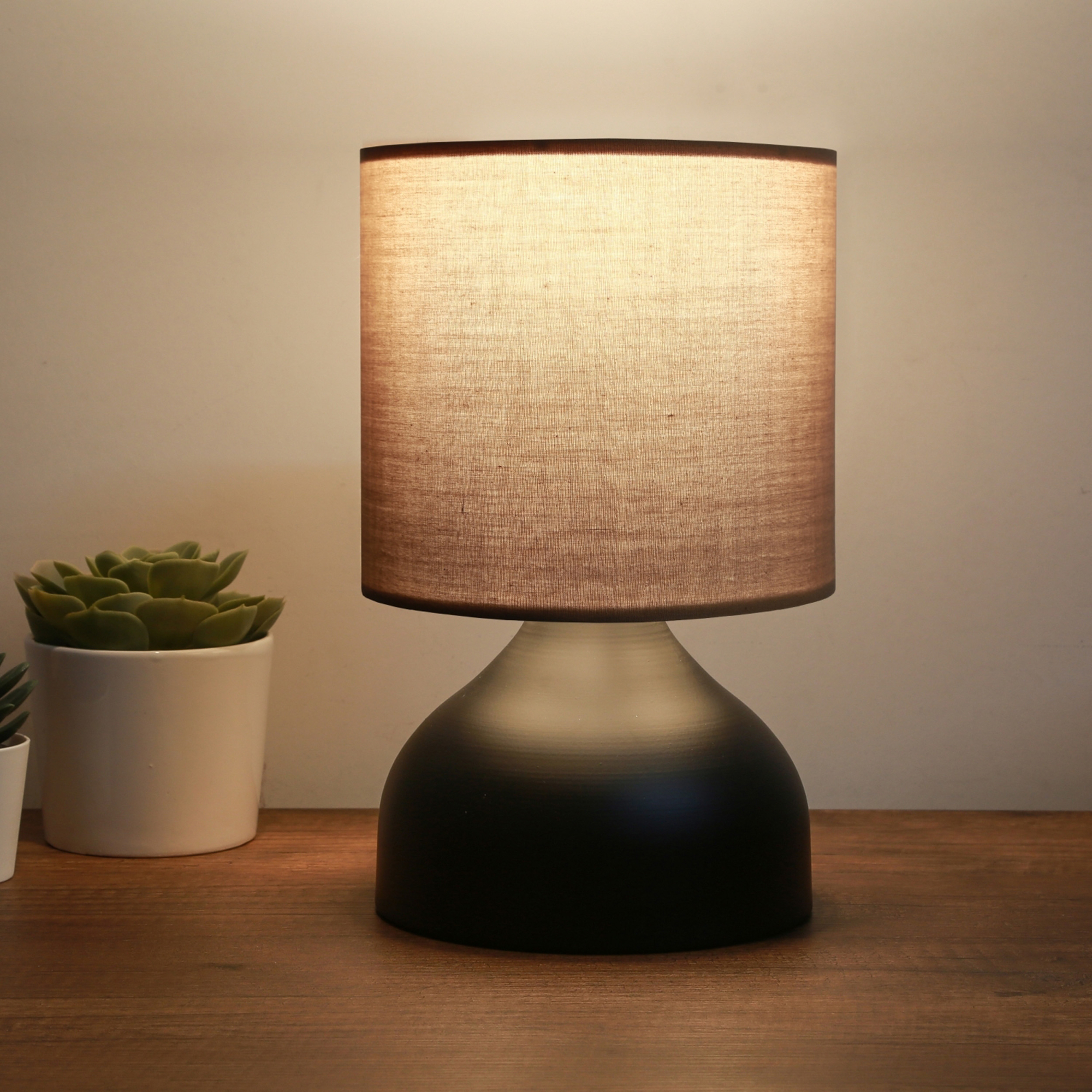Image of Lampada da Comodino &#39;Shoreham&#39; Lampada da Tavolo con Base in Metallo Nero e Paralume Cilindrico in Tessuto Marrone -